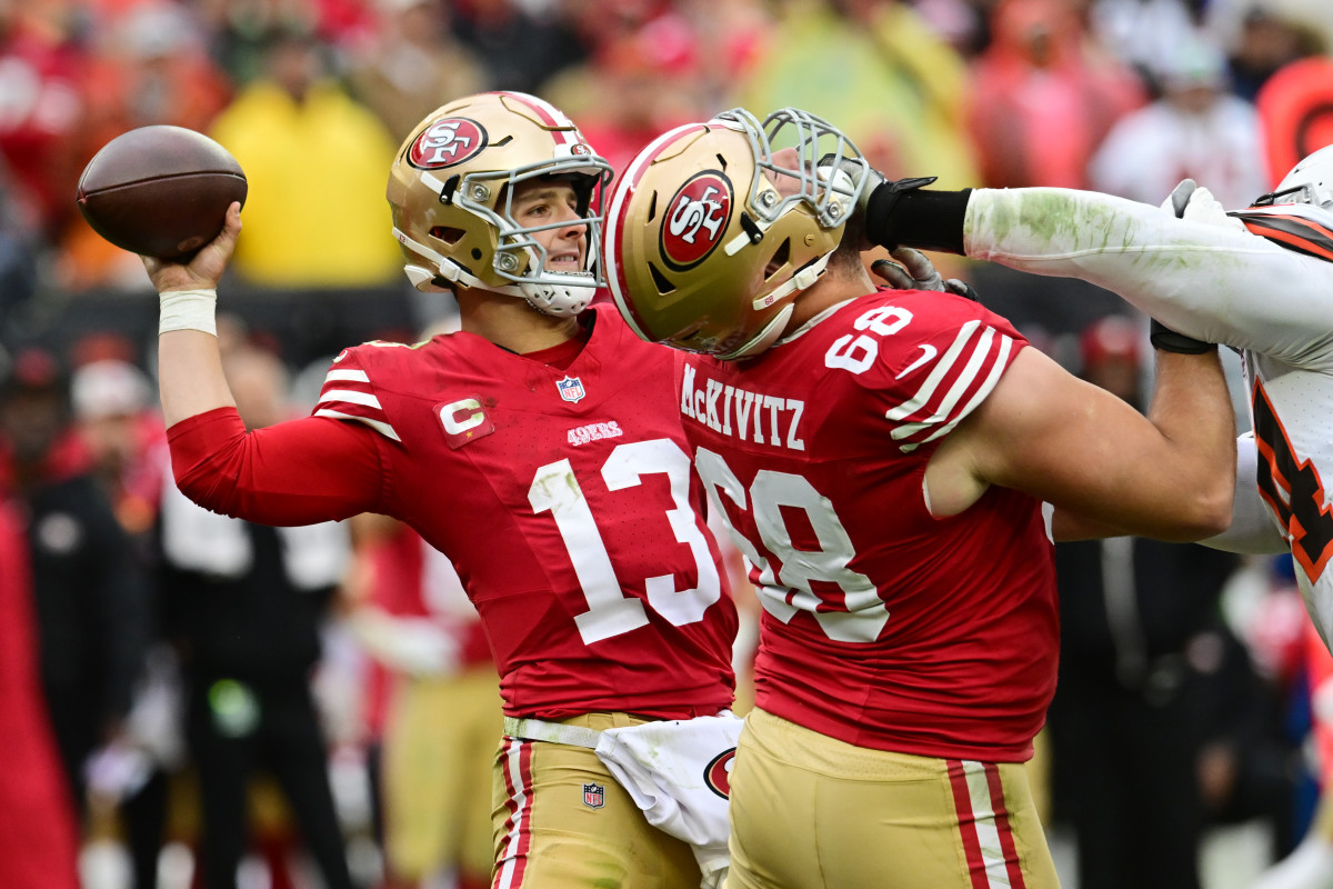 Brock Purdy throws the ball as Colton McKivitz blocks in front of him